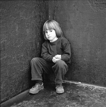 Childhood Fear Worried girl crouching in corner